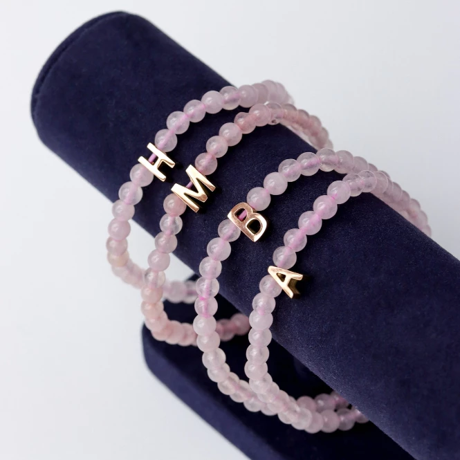 LUCY SUMMER กำไลข้อมือหินแท้ Rose Quartz (โรสควอตซ์) ขนาด 4 mm พร้อมจี้ตัวอักษร Alphabet A-Z — ของมงคลหมวดความรักและความสัมพันธ์